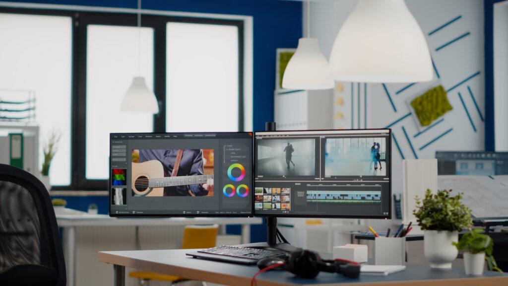 VERZEX agency office with dual monitors setup with processing video film montage. Video editing start-up studio company with no people in it and post-production software on pc displays
